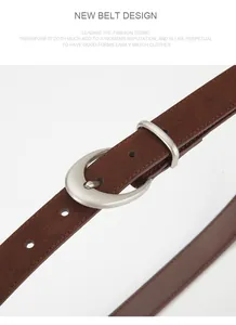 Close-up of matte leather belt with silver oval buckle and fine grain texture
