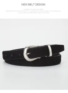 Detailed macro view of black suede leather belt showing matte texture and silver horseshoe buckle