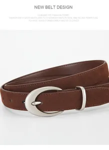 Detail of brown matte suede belt with a silver oval buckle and stitching on white backdrop