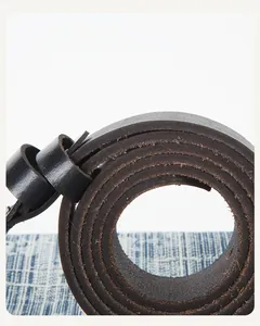 Gros plan sur l'épaisseur de la ceinture en cuir véritable avec bords texturés et fibres