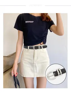 Détail de ceinture en cuir noir pour femme avec une boucle ronde argentée à texture fine