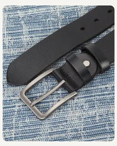 Gros plan d'une ceinture en cuir noir avec boucle à ardillon en métal brossé argent