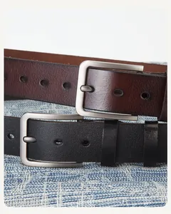 Gros plan de ceintures en cuir de qualité avec boucles argentées brossées noires et brunes