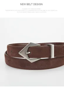 Macro shot of dark brown suede leather belt with unique silver geometric arrow buckle