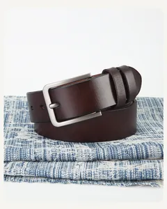 Détail de ceinture en cuir marron foncé avec boucle métallique argentée brossée
