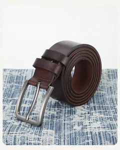 Détail d'une ceinture en cuir marron foncé pour homme avec boucle ardillon argentée