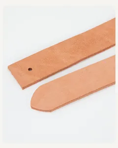 Macro detail of natural tan leather belt strap showing grain texture and punched holes