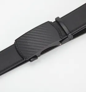 Détail de la ceinture en cuir noir avec boucle en carbone et motif de clé grecque