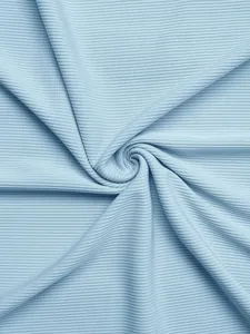 Detailed close-up of light blue ribbed knit fabric showing soft texture and vertical patterns