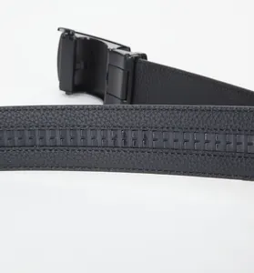 Détail d'une ceinture en cuir noir avec rail à cliquet et boucle en métal mat