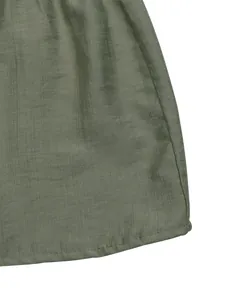 Detailed close-up of army green woven dress hem featuring professional stitching and fabric texture