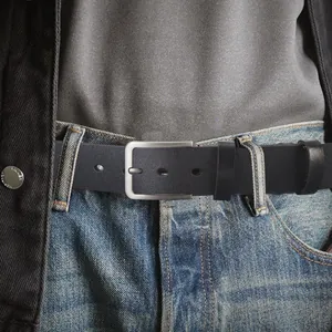 Ceinture en cuir noir pour homme avec boucle ardillon argent mat sur un jean bleu
