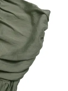 Detail of olive green linen fabric texture and layered ruffle folds on a backless dress