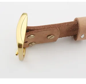 Dettaglio della cintura in pelle vintage con fibbia in ottone e bordi in fibra naturale