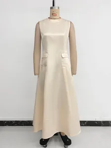 Detail of elegant beige sleeveless satin maxi dress featuring decorative flap pockets