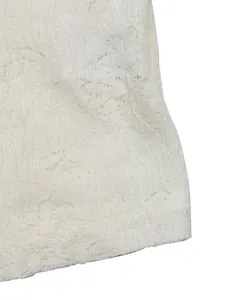 Macro detail of white floral lace fabric with intricate embroidery and hollow out texture