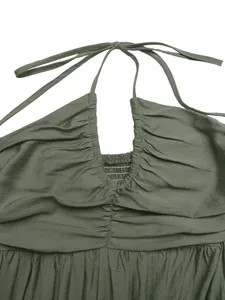 Detailed view of the olive green halter dress featuring a ruched bodice and smocked texture