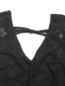 Détail du haut en dentelle noire avec décolleté en V transparent et nœud élégant