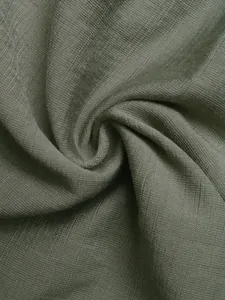 Macro detail of olive green linen fabric showing natural woven texture and soft drape