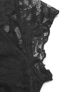 Vue macro détaillée du tissu en dentelle noire avec motifs floraux ajourés et maille