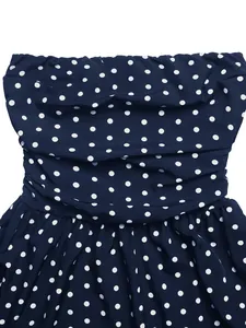 Detailed view of dark blue polka dot dress featuring tiered ruffles and pleated bodice