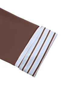 Gros plan détaillé de la manche en tricot marron avec poignets contrastés rayés bleus