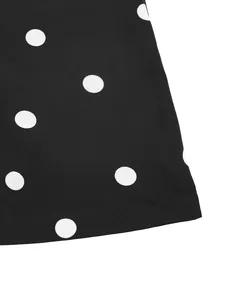 Macro shot of polka dot pattern on black fabric with clean stitched hem details