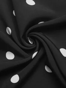 Macro shot of black fabric with white polka dots showing smooth texture and soft drapes