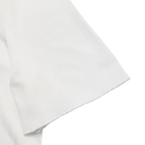 Primo piano del tessuto in maglia a costine bianco con texture e cucitura dell'orlo