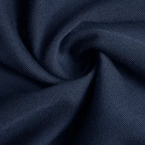 Gros plan sur le tissu bleu marine de la robe avec motif sergé et drapé élégant