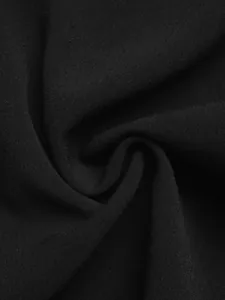 Detailopname van de zwarte textielstructuur met fijne weving en zachte drapering