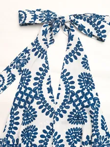 Dettaglio ravvicinato del collo all'americana con stampa a foglie blu su abito bianco