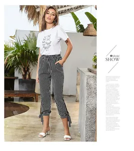Detail of high waist striped pants with side bow-knot ribbons and butterfly print