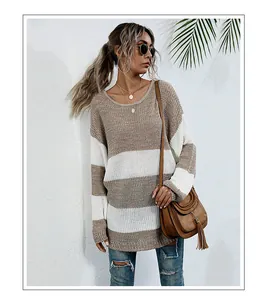 Dettaglio del maglione a righe marroni e bianche oversize con borsa a tracolla con frange