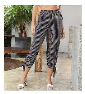 Close-up of high-waisted black and white striped pants with decorative bow cuffs