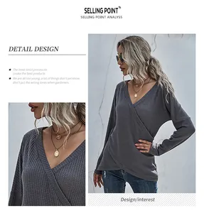 Detail of gray waffle-knit wrap top showing V-neckline texture and cross design