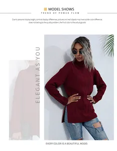 Gros plan du pull col roulé rouge bordeaux avec motifs torsadés et fentes latérales
