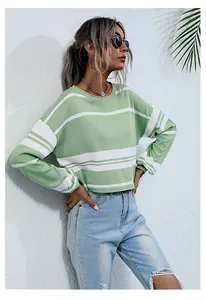 Close-up of women's green and white striped knit sweater with crew neck and drop shoulder