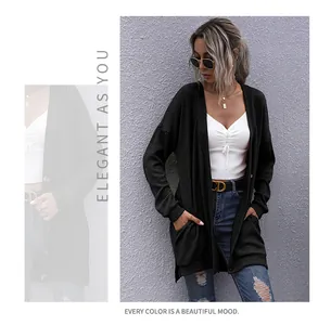 Détail de la texture d'un cardigan noir en maille avec côtes et poignets ajustés