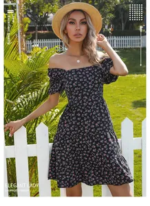 Détail de robe fleurie à manches bouffantes, jupe à volants et décolleté chic à épaules nues