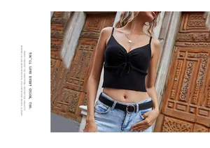 Détail d'un crop top noir en maille côtelée avec décolleté en V et cordon devant
