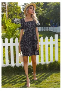 Robe fleurie à manches bouffantes avec col carré vintage dans un jardin ensoleillé