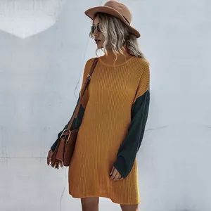 Detail of color-block knit dress featuring chunky texture and warm turtle neck design
