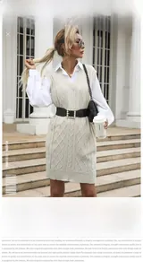 Close-up of cable knit texture on a beige V-neck vest dress and white long sleeve shirt