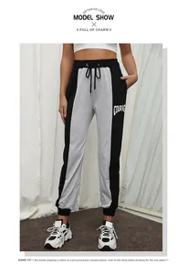 Detail showing color-block joggers with COURAGE lettering and drawstring waist