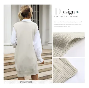 Detail view of beige knit vest with ribbed hem and texture over a white shirt