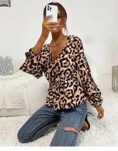 Close-up of leopard print V-neck blouse with lantern sleeves and gathered waist detail
