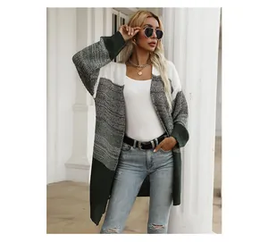 Detail of color-block knit cardigan in white, grey and dark green with textured stitch