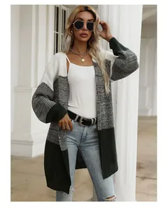 Detail of color-block knit cardigan featuring white, grey, and dark green segments