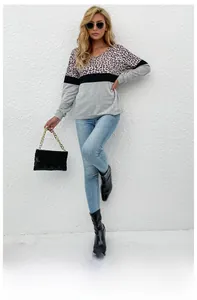Close-up of leopard print patchwork V-neck top with contrasting black and grey panels